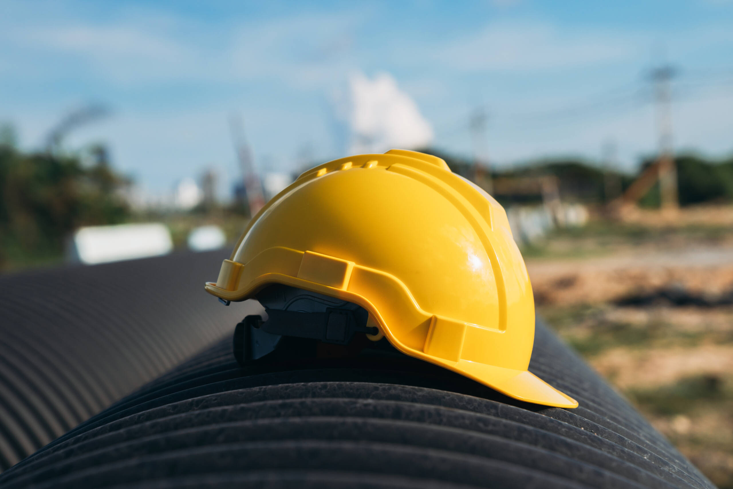Yellow engineer hard safety helmet hat on Circular water Pipe. Construction and Oil Natural Gas and fuels Transport concept.